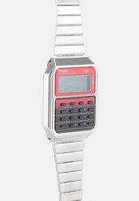 Relógio digital com um caixa retangular em prata, visor vermelho e preto, bracelete de metal e vários botões para configurações e funções.