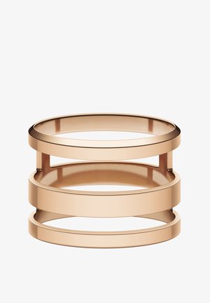 Bangle z różowego złota z trzema stakowanymi okrągłymi pierścieniami o gładkich, wypolerowanych krawędziach i otwartych przestrzeniach między każdym pierścieniem.