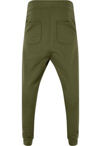 Olivgrüne Jogginghosen mit elastischem Bund, schmal zulaufenden Beinen und zwei Gesäßtaschen. Aus weichem Stoff mit glatter Textur gefertigt.