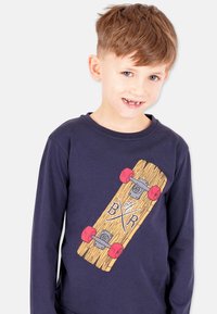 Marineblaues Langarmshirt mit einem grafischen Motiv eines Holzskateboards mit roten Rädern und weißen Buchstaben, aus weichem Textilmaterial gefertigt.