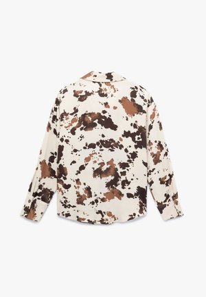 Camisa de manga larga en crema con estampado abstracto de salpicaduras en marrón y negro. Presenta un cuello con solapa y puños con botones. Textura de tela suave.