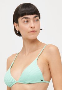 Bikini top u svijetlozelenoj boji, trokutastog kroja, s rebrastom teksturom, tankim podesivim trakama i malim logom s strane.