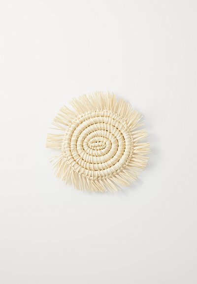 Woven circular mat made of light-colored straw, featuring a spiral design with fringe edges, set against a plain white background.