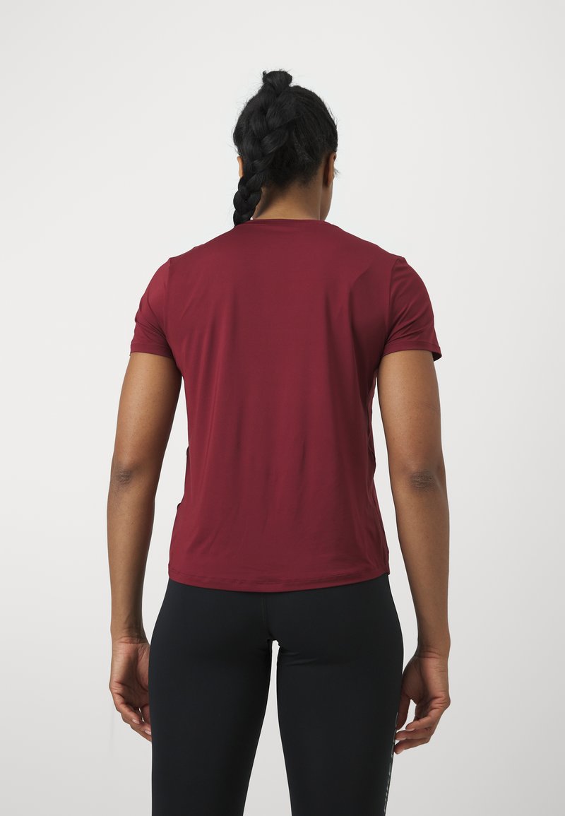 Chemise bordeaux à manches courtes avec un col rond, texture lisse et design ajusté, vue de dos avec un pantalon noir.