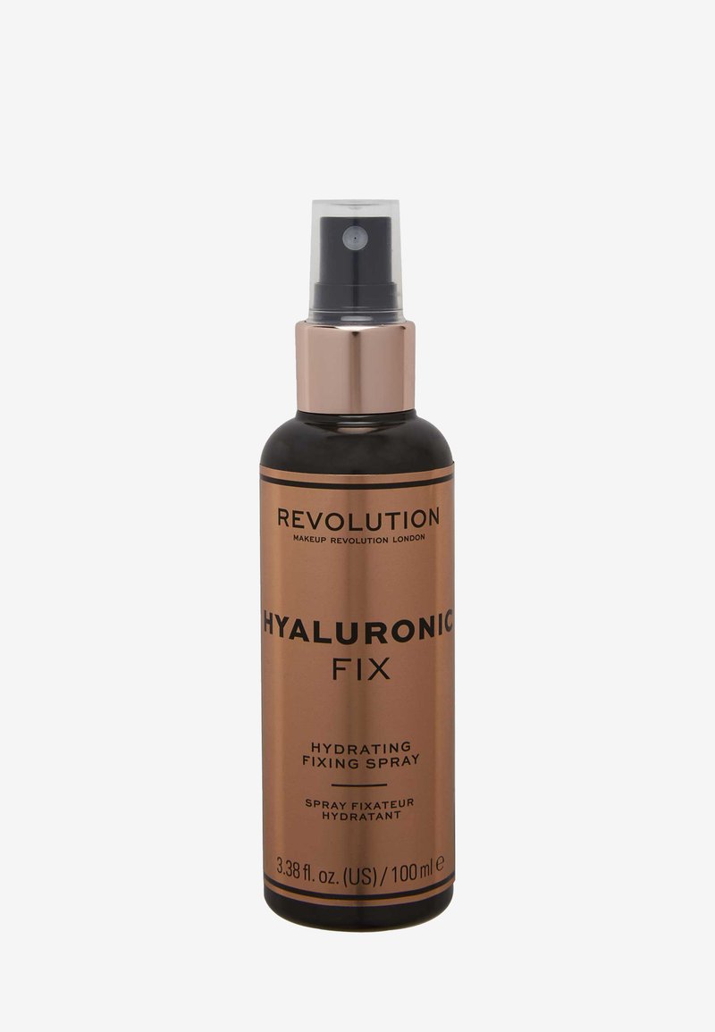 Zwarte cilindrische fles met een gouden metalen pomp. Etiket vermeldt “Hyaluronic Fix,” met details over hydraterende en fixerende spray. Grootte: 100 ml.