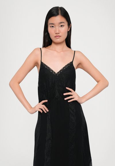 Must mustrõng mustriline särk õhukeste rihmadega, millel on V-kujuline kaelus ja keerukad pitsdetailid bodice'il ja külgedel. Sujuv tekstuur.