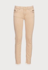 Jeans skinny beige con cierre de botón frontal, bolsillos con cremallera frontal con anillas de metal, pasadores para cinturón y dobladillos deshilachados.