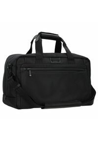 Sac de sport noir en tissu durable, de forme rectangulaire, avec des poignées supérieures, une bandoulière et une poche frontale zippée.