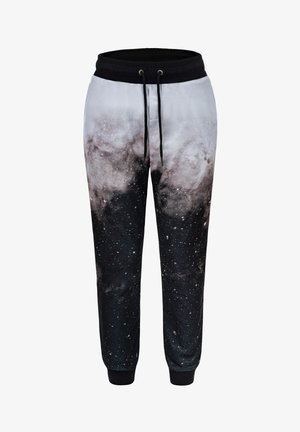 Spodnie dresowe w motywie galaktyki, wykonane z miękkiego materiału, z czarno-białym nadrukiem kosmicznym, elastycznym paskiem w talii oraz ściągaczami przy mankietach.
