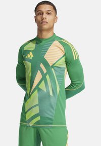 Groene sporttrui met lange mouwen, voorzien van hoekige gele en groene patronen, gestipte texturen en contrasterende stiksels; slim fit ontwerp.