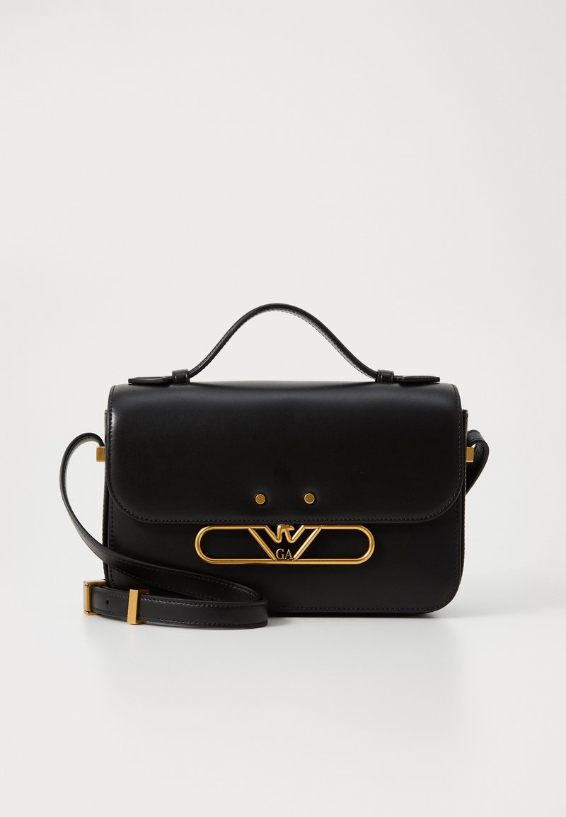 Borsa a mano in pelle nera con una forma strutturata, hardware color oro con una chiusura a logo, manico superiore e tracolla removibile.