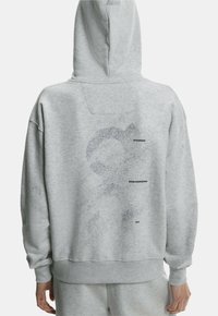 Gray hooded sweatshirt with a relaxed fit, featuring a dotted graphic and text "ON RUNNING," "SWISS ENGINEERING," and "2010" on the back.