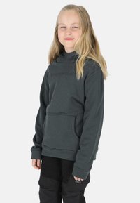Gray hoodie with a front pocket, featuring a high neck and relaxed fit, paired with black pants. Subtle branding on the chest.