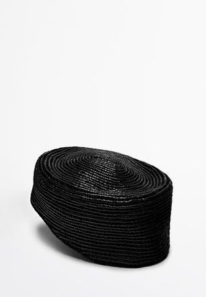 Cappello intrecciato nero con una forma ovale, caratterizzato da fibre disposte in modo compatto che creano una superficie testurizzata. Finitura liscia con una parte superiore piatta.