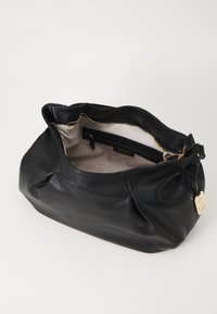 Sac en cuir noir au design doux et décontracté. Avec une fermeture à glissière dorée et un intérieur clair avec une poche latérale. Étiquette de marque visible.