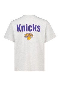 Gray cotton t-shirt featuring "Knicks" printed in bold purple letters and a basketball graphic. Crew neck with short sleeves.