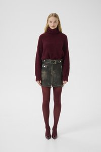 Burgundy oversized sweater with a turtleneck, black leather mini skirt with belt and zippers, maroon tights, and pointed-toe heels.