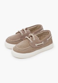 Braune Stoffschuhe mit weißen Gummisohlen, Schnürdesign, gestickten Details und metallischen Ösen für die Schnürsenkel. Abgerundete Schuhspitze.