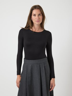 Zwarte blouse met lange mouwen en een ronde hals, gecombineerd met een hoogstaande, geplooide grijze rok van een textuurstof.