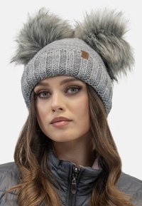 Gray knitted beanie with two large faux fur pom-poms on top, featuring a ribbed design and a small brown label on the side.