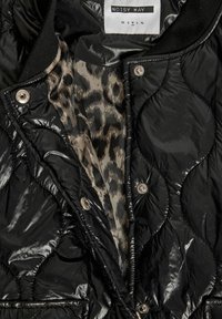 Μαύρο καπιτονέ μπουφάν με εσωτερική φόδρα σε μοτίβο λεοπάρδαλης, κλείσιμο με κουμπιά τύπου σναπ και ετικέτα "NOISY MAY" που εμφανίζει επιλογές μεγέθους από XS έως XL.