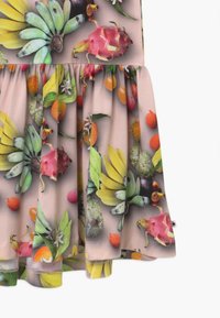 Leikkaukseltaan avara mekko, jossa on eläväinen hedelmäkuvio, jossa on värejä kuten vihreä, vaaleanpunainen ja oranssi pehmeällä beige-taustalla. Valmistettu kevyestä kankaasta.