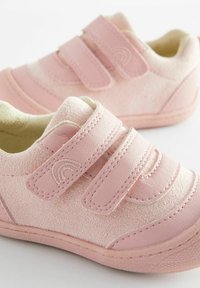 Zapatillas infantiles rosas con textura de ante, que cuentan con dobles correas de Velcro y sutiles detalles de costura. Forro suave y suela de goma.