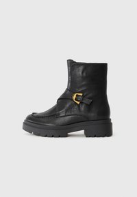 Botine negre din piele, cu vârf rotund, fermoar lateral, o curea cu detalii din cataramă aurie și o talpă din cauciuc chunky cu profil.