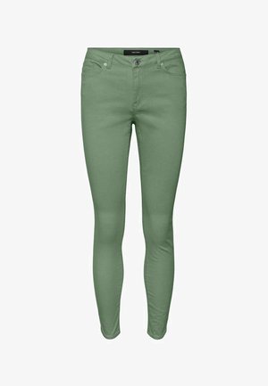 Jeans skinny verts en mélange de coton extensible, dotés d'un design classique à cinq poches et d'une braguette zippée avec fermeture par bouton.