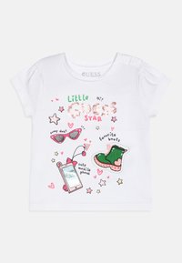 Tricou alb cu mânecă scurtă, având imprimeuri grafice colorate, text strălucitor și imagini cu ochelari de soare, un telefon și o botină verde.