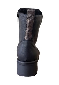 Zwarte leren enkellaars met gestructureerde bronzen accent, achterrits en stevige rubberen hak. Lichtjes afgeronde teen en zachte binnenvoering.