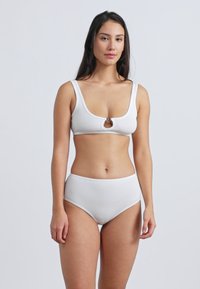 Λευκό σετ μπικίνι με ριμπ ύφασμα που περιλαμβάνει τοπ με στρογγυλή λαιμόκοψη και μπροστινό άνοιγμα, καθώς και σλιπ με ψηλή μέση. Λείο υλικό χωρίς σχέδια.