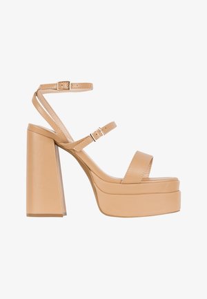 Beige platform hoge hak sandaal met een chunky blokhak, verstelbare enkelbandjes en een zachte leren textuur. Minimalistisch design.