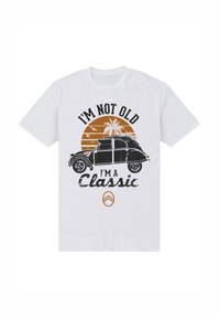 Bílá bavlněná tričko s retro autem na grafice, s černým a oranžovým textem: "NEJSEM STARÝ, JSEM KLASIKA," a palmami v pozadí.