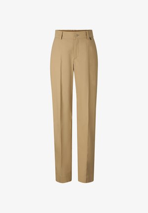 Beżowe spodnie o prostych nogawkach z zapięciem na guzik i zamek błyskawiczny, szlufkami na pasek oraz starannie wykonanym kantem z przodu na każdej nogawce.