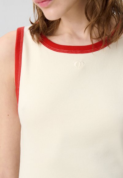 Top senza maniche a coste in crema con collo e armholes in rosso a contrasto. Presenta un piccolo logo in rilievo sul davanti. Tessuto morbido.