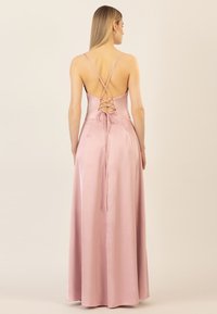 Rosa Satin-Maxi-Kleid mit tailliertem Oberteil, gekreuzten Trägern und Schnürdetail am Rücken. Glatte Textur und fließende Silhouette.