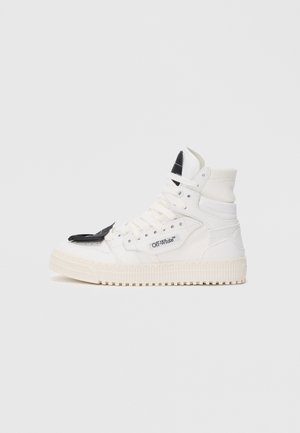 Visoke tenisice od bijele tkanine s crnim detaljima, okrugli vrh, debeli đon, ravne vezice i oznaka branda sa strane.