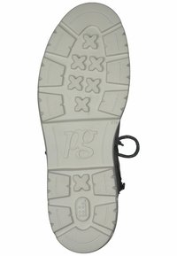 Suela de un zapato que presenta un material de goma blanca texturizada con un diseño de relieve en el dibujo y un logo, moldeada con bordes redondeados.