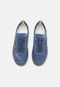 Μπλε σουέτ αθλητικά παπούτσια με λείο υφή, που διαθέτουν μαύρες δερμάτινες λεπτομέρειες και ταιριαστή κλεισίματος με κορδόνια, τοποθετημένα σε καφέ καουτσούκ σόλα.