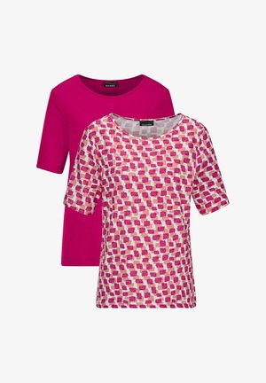 Twee dames tops met korte mouwen, één effen magenta en één wit met een patroon van roze en perzikkleurige vierkante penseelstreken.