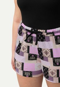 Shorts kuviolliset, joissa on musta, laventeli ja beesi yhdistelmä kukka- ja geometrisilla kuvioilla. Rento vyötärö, jossa on kiristysnauha.
