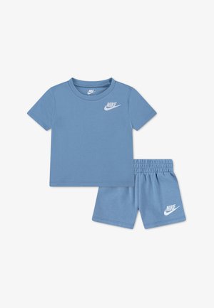Conjunto de camiseta azul de manga corta Nike y pantalones cortos con cintura elástica, con el logotipo blanco de Nike en el pecho y la pierna izquierda, colocado sobre un fondo blanco.