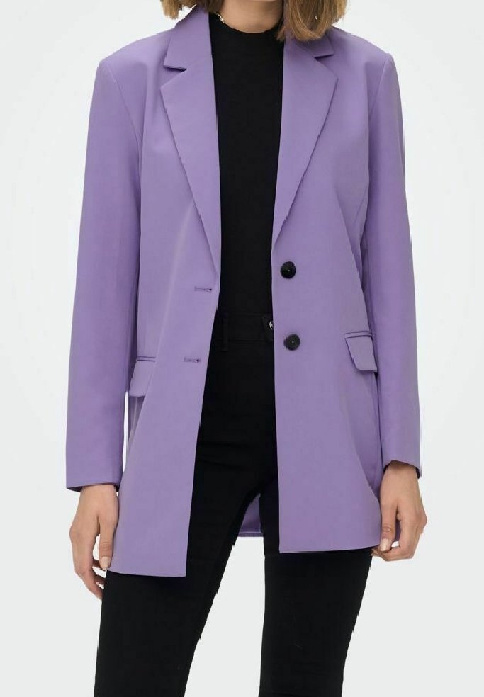 Lila bleiser, skreddersydd design med lange ermer, to svarte knapper og frontlommer. Brukt over en svart topp med svarte bukser.