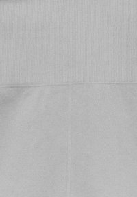 Světle šedá látka se dvěma různými texturami: na vrchu je tkaný pletený vzor a na dně hladká, jednolitá pletenina.