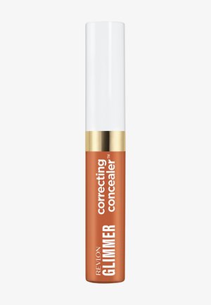 Correcteur correcteur Revlon Glimmer en teinte orange avec un capuchon blanc et une bande d'accent dorée, debout sur un fond blanc.