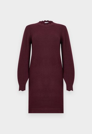 Langærmet, knælang bordeaux strikket kjole med bølget halsudskæring og tætsiddende manchetter, vist mod en ensfarvet lys baggrund.