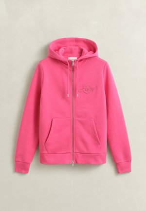 Sweat à capuche zippé rose vif avec poches avant, capuche réglable par cordon et logo brodé discret sur la poitrine, présenté sur un fond neutre.