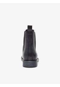 Schwarze Leder-Stiefelette mit glatter Oberfläche, runder Zehenform und kleinem Absatz. Verfügt über eine Zuglasche und seitliche elastische Einsätze für einfaches An- und Ausziehen.