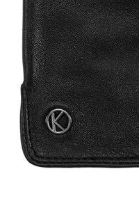 Czarny skórzany portfel o fakturowanej powierzchni, z srebrnym logo na guziku i kontrastowym przeszyciem wzdłuż krawędzi.